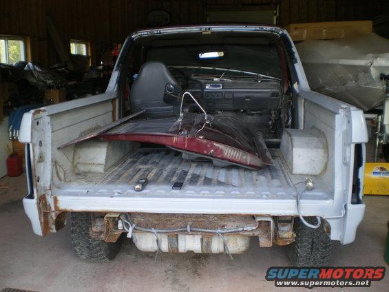 1988 Ford Bronco with doors removed and interior disassembled, parked in a garage