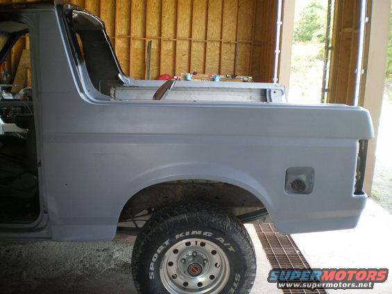 Gray SUV body, side view, showing rear quarter panel and tire