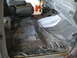 1988 Ford Bronco - The interior of a vehicle shows significant wear and tear, with exposed metal and wiring.