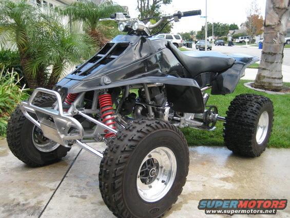 Black quad bike with chrome front bumper and red shocks