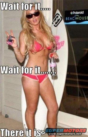 Woman in a pink bikini holding a bottle and a phone, standing next to a surfboard. Text overlays say 'Wait for it...' and 'There it is'
