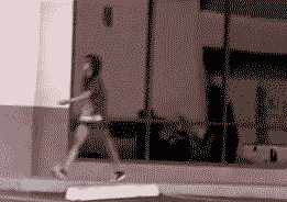 Person walking in front of a building with large windows