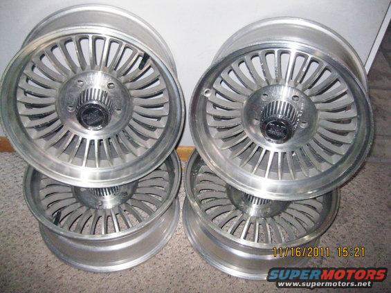 Four aluminum alloy wheels stacked, with a date stamp of 11/16/2011