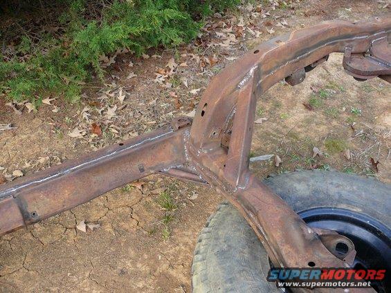 rusted vehicle frame with some new welds, tire visible