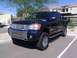 2008 Nissan Titan - Dark blue 2008 Nissan Titan pickup truck with aftermarket grille and wheels parked in a lot.