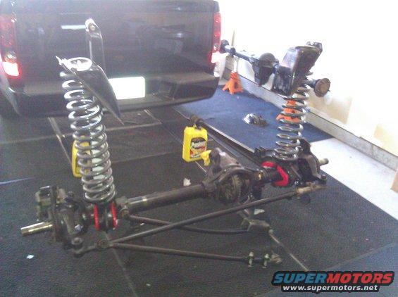 Front axle assembly with coil springs and shocks, partially disassembled