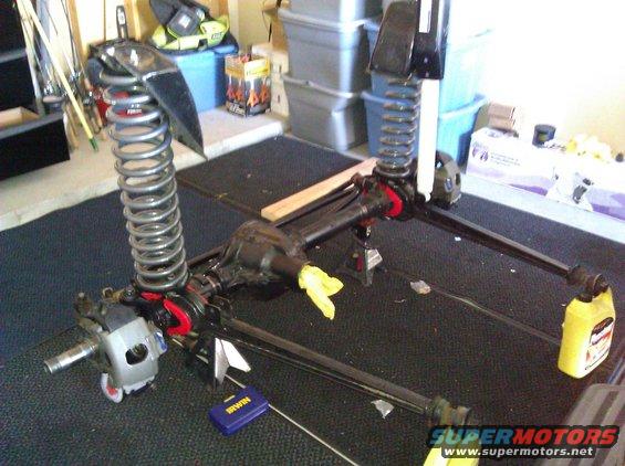 Front axle assembly with coil springs and shock mounts, on jack stands