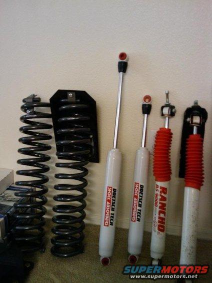 Two sets of coil springs and four shock absorbers, some with red boots