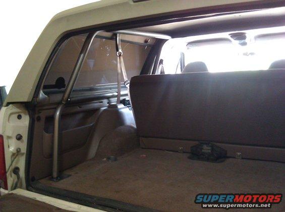 Tan interior of a 1992 Ford Bronco with a metal roll cage installed behind the front seats