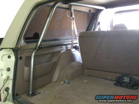 Interior view of a 1995 Ford Bronco showing a custom roll cage installed behind the front seats