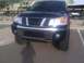 2008 Nissan Titan - Front view of a dark blue Nissan Titan pickup truck with a chrome grille and large tires, parked in a lot.