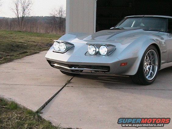 Silver sports car front view, parked on concrete driveway