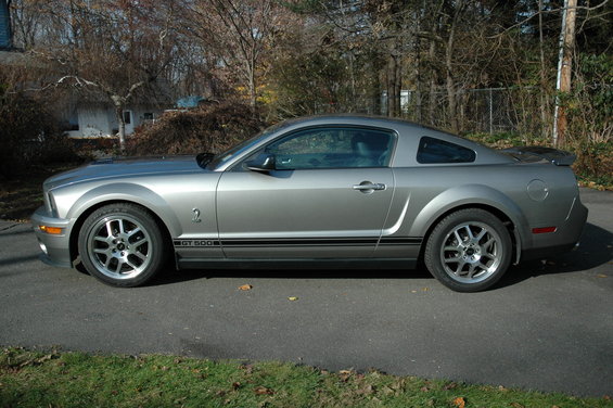 Silver 2008 Ford Mustang GT 500 side view with black racing stripes