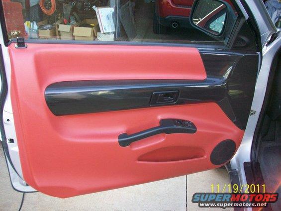 Red interior door panel with black trim and speaker grille