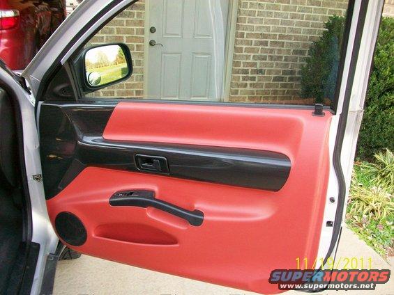 Red and black interior door panel with a side mirror visible