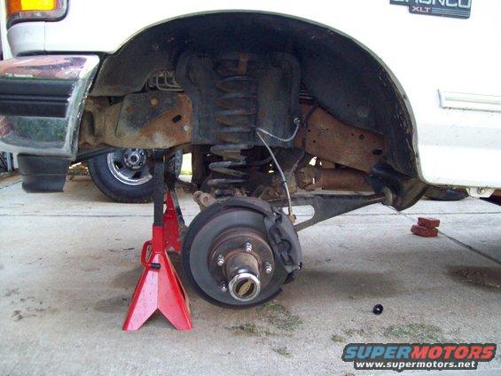 1996 Ford Bronco XLT rear suspension on jack stands, showing lifted components and brake assembly
