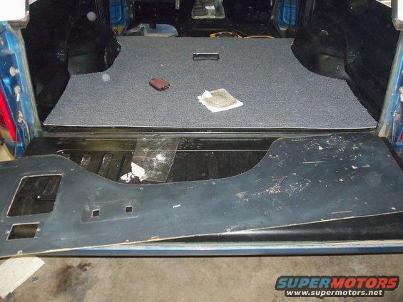Interior cargo area with gray carpet and removed black trim panel