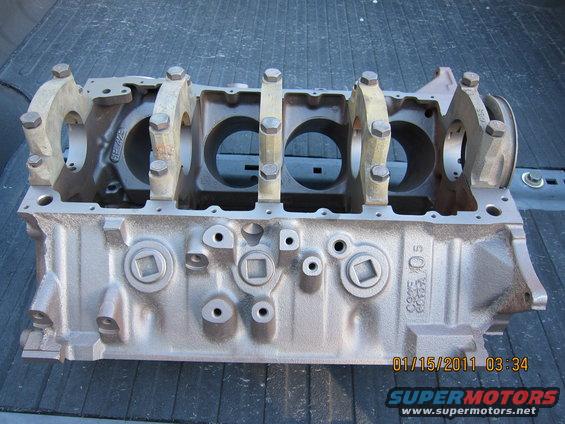 Engine block with crankshaft bearing caps attached, viewed from the side