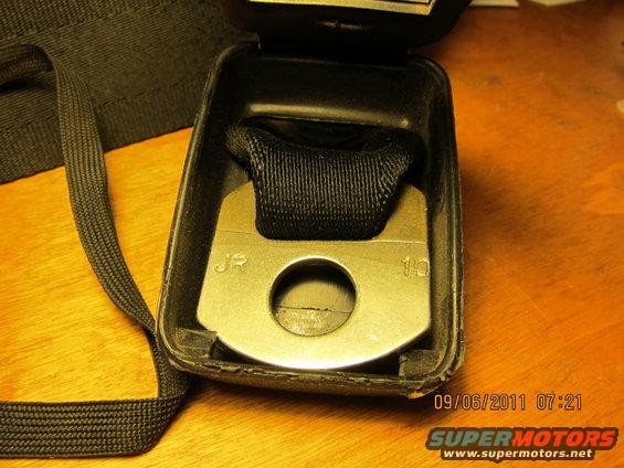 Seatbelt buckle with JR and 10 stamped on metal plate, black webbing, and black plastic casing