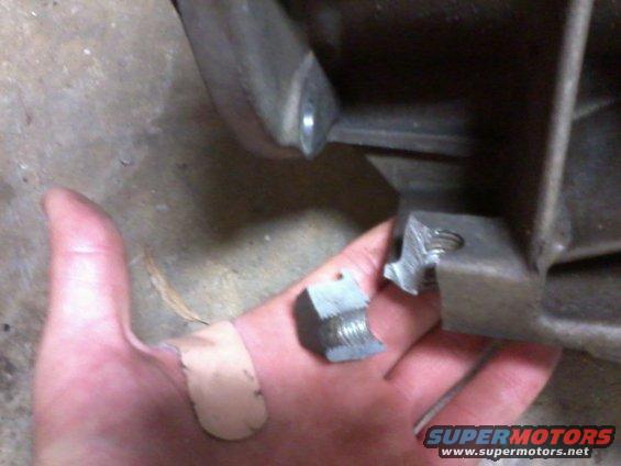 Hand with band-aids holding a broken bolt and nut