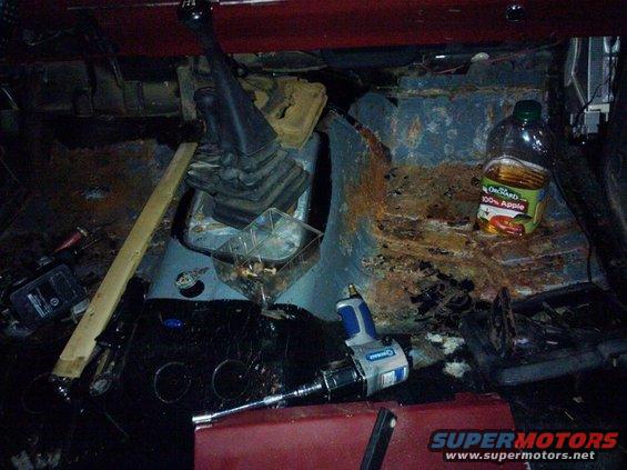 Interior view of a rusty truck cab with a floor shifter and an impact wrench