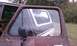1979 Ford Bronco - Reflection in the window shows the rear of the vehicle. The paint is peeling on the door.