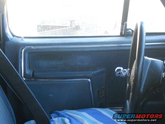 Interior door panel with chrome handle and part of steering wheel