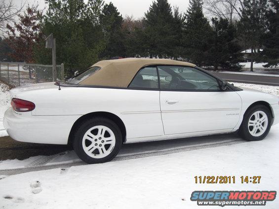 White convertible with tan top parked in snow. "Chrysler" badge visible on the side