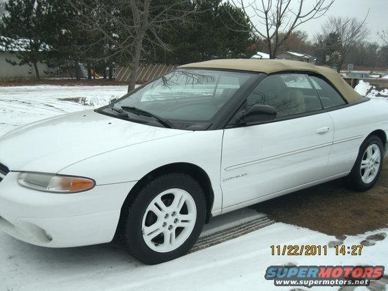 White convertible parked in snow. The word "CHRYSLER" is visible on the side