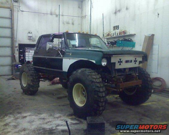 1978 Chevrolet C/K Pickup modified with lift kit and oversized tires, parked indoors
