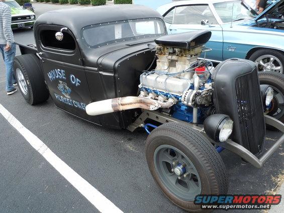 Black hot rod truck with exposed engine and "House of Hot Rods" text on door