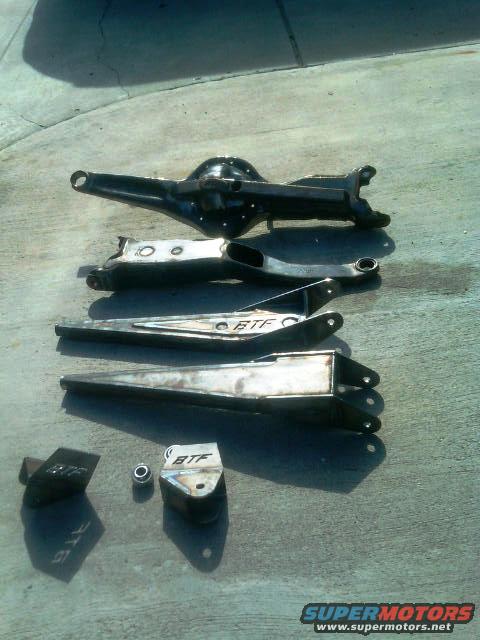 BTF suspension parts laid out on concrete, including a differential housing and control arms