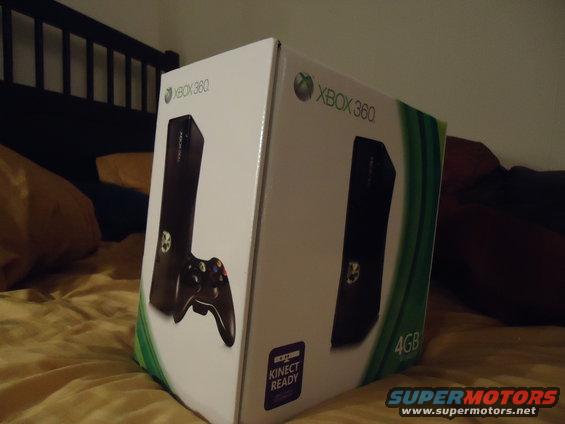 Xbox 360 console box with controller graphic, on a bed