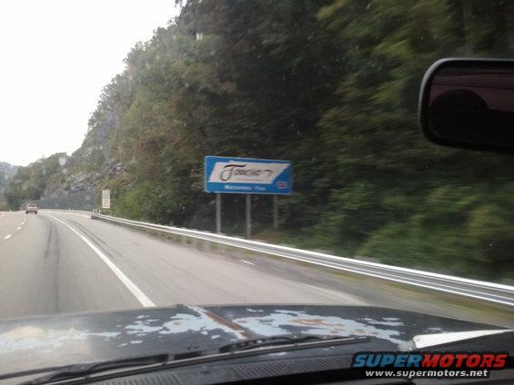 Driving past a sign that says "Tennessee Welcome". Another car is visible on the road ahead