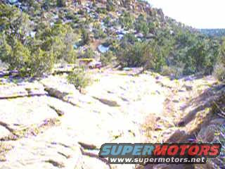 Yellow vehicle on rocky terrain with SuperMotors logo