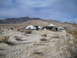 1986 Ford Bronco - A desert scene with multiple tents and vehicles set up, likely for an off-road event or camping trip.