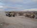 1986 Ford Bronco - A custom off-road truck navigates a dusty desert course under a cloudy sky.