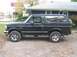 1993 Ford Bronco - A black 1993 Ford Bronco is parked on a gravel surface next to a building.