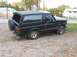 1993 Ford Bronco - This black 1993 Ford Bronco is viewed from the rear three-quarter angle, showing its spare tire mounted on the tailgate.