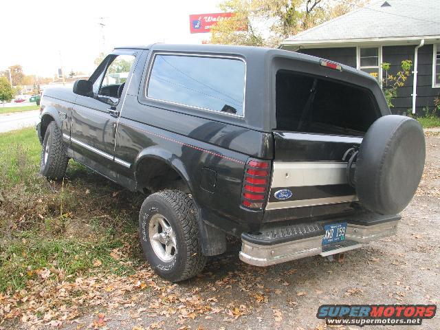 1993 Ford Bronco parked on grass, rear view. Spare tire mounted on back