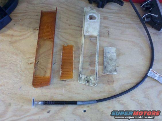 Disassembled amber and clear plastic vehicle light lenses and housings on a wooden surface
