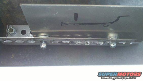 Metal bracket with visible text and fasteners, attached to an unseen surface