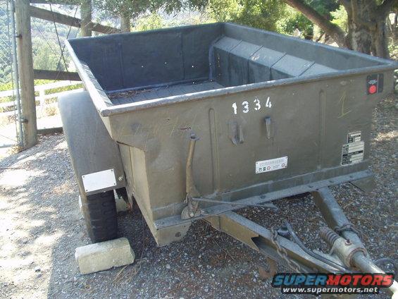 Olive drab military trailer with number 1334 painted on the side, parked outdoors