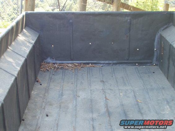 Empty truck bed with some leaves and debris on the floor and sides