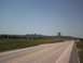 2007 Dodge Caliber - A road stretches towards the iconic Devils Tower formation in a vast, open landscape.