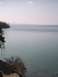 2007 Dodge Caliber - A landscape captures a cliffside with trees meeting a vast, tranquil body of water under a hazy sky.