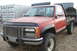 1994 GMC Sierra 3500 - This red pickup truck features a flatbed and appears to be from the mid-1990s.