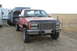 1994 GMC Sierra 3500 - This red GMC pickup truck is equipped with a flatbed and towing a large trailer.