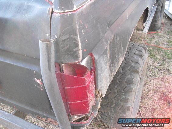 Rear driver's side of a Ford Bronco with a damaged taillight and rust on the quarter panel