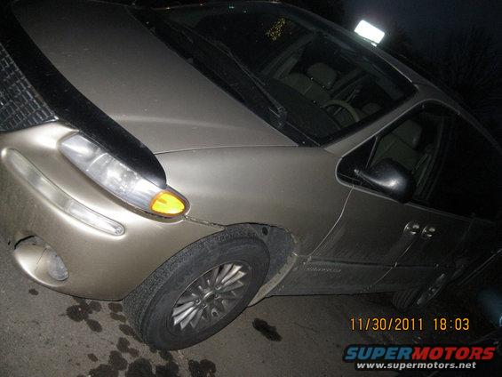 Tan minivan, front quarter view. Has a black hood protector